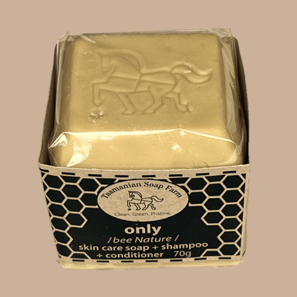 A 70g bar of 'only' skin care soap and shampoo from Tasmanian Soap Farm, wrapped in clear cello and presented in its black and buff honeycomb-patterned cardboard box, set against a solid beige background.