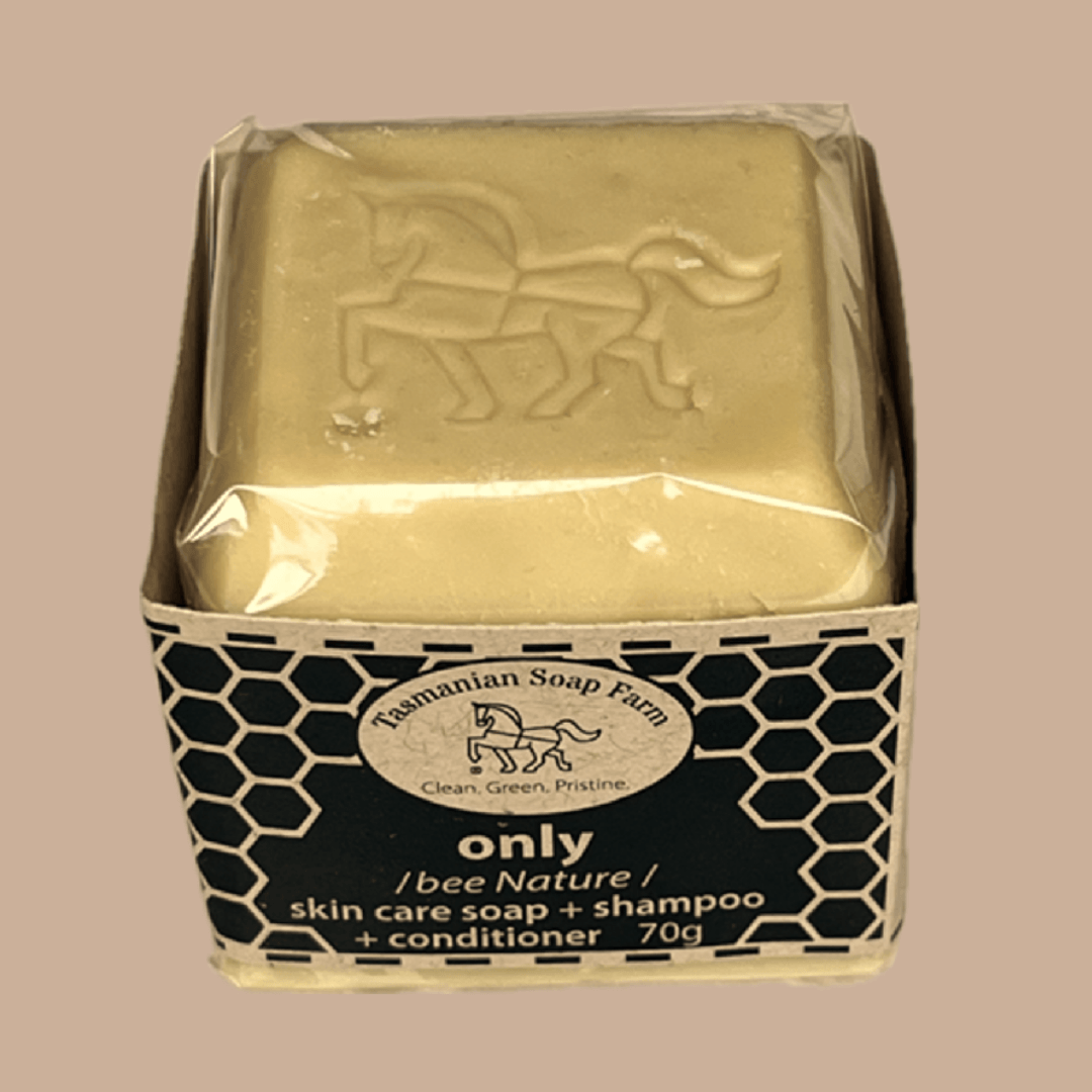 A 70g bar of 'only' skin care soap and shampoo from Tasmanian Soap Farm, wrapped in clear cello and presented in its black and buff honeycomb-patterned cardboard box, set against a solid beige background.