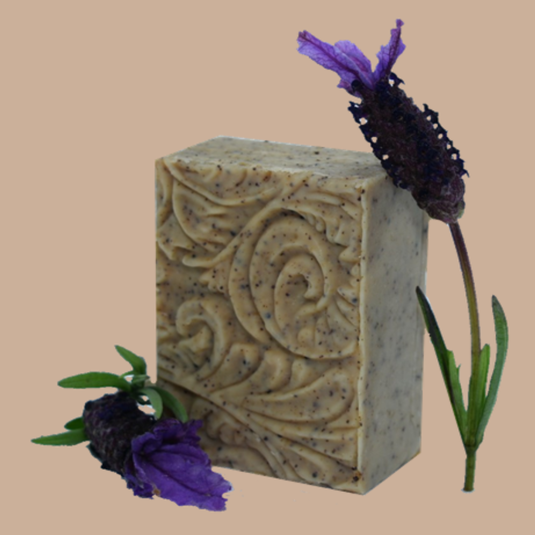 A Tasmanian Soap Farm embossed lavender soap bar with purple lavender flowers placed on and beside it, set against a solid beige background.