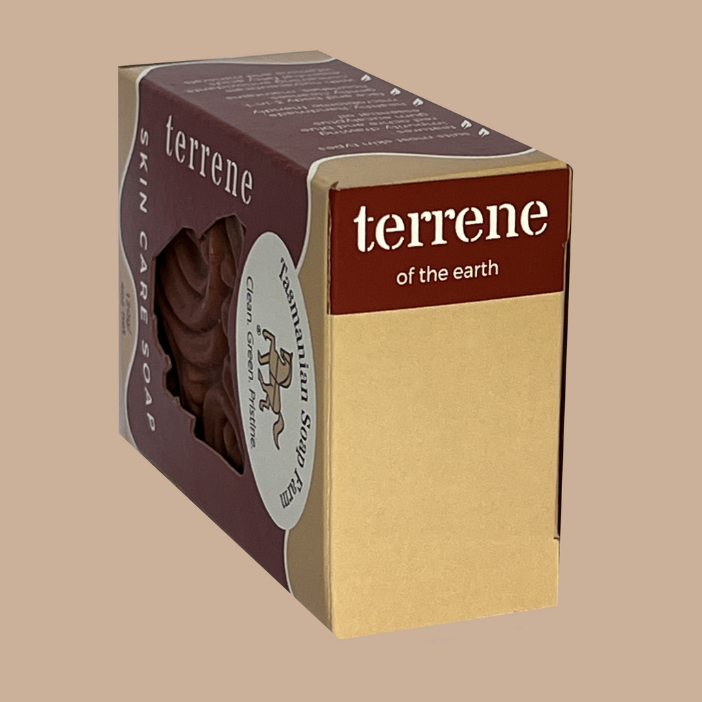 A boxed bar of skin care soap, by Tasmanian Soap Farm, labelled 'terrene' and 'skin care soap' on a plain beige background. The packaging is dark red and kraft beige with a clear window showing the soap bar inside.