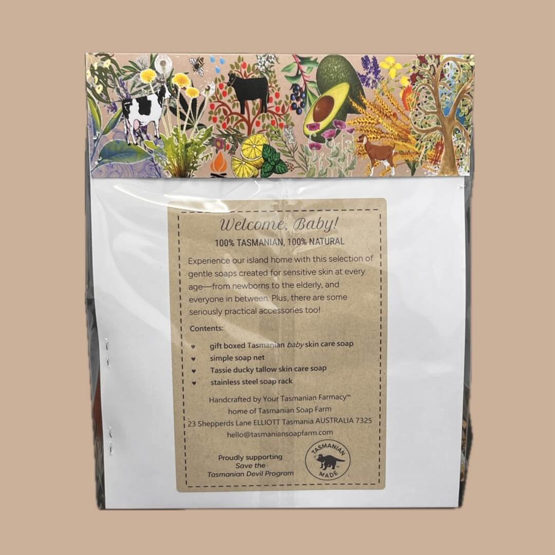 A packaged baby skincare set from Tasmanian Soap Farm, featuring a white card with a detailed product description insert and a colourful illustrated backing card showing cows, flowers, and ingredient motifs.