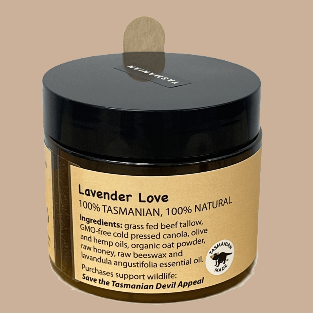 A jar of Lavender Love tallow treatment by Tasmanian Soap Farm featuring a black lid and a tan label with product details, set against a solid tan background.